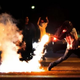 In Ferguson, Mo., a demonstrator picks up a tear gas cannister and throws it back at police four days after the Aug. 9, 2014, shooting death of Michael Brown by police.
Robert Cohen/St. Louis Post-Dispatch